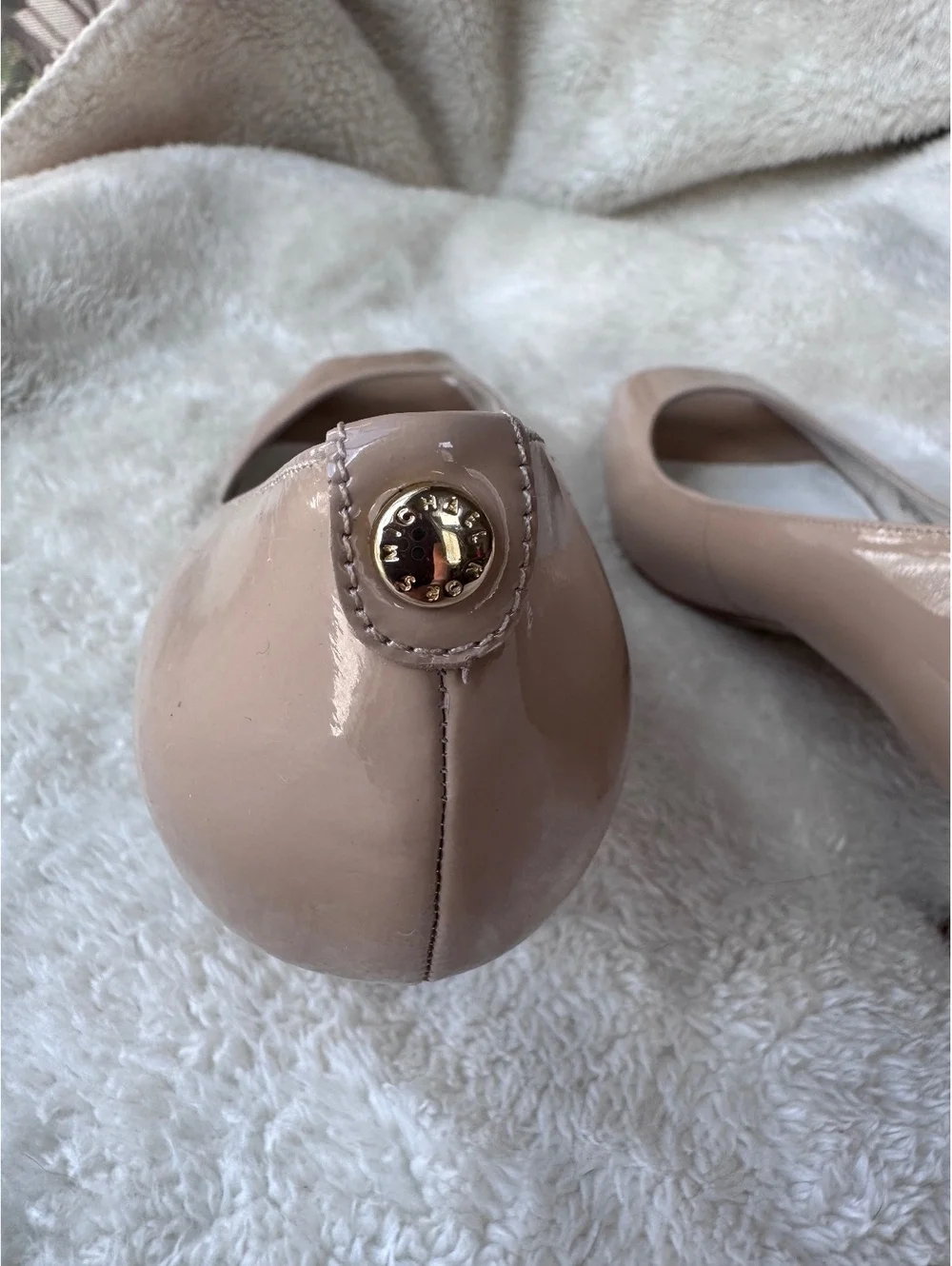 Michael Kors women’s patent leather peep-toe pumps in a classic nude/blush color
